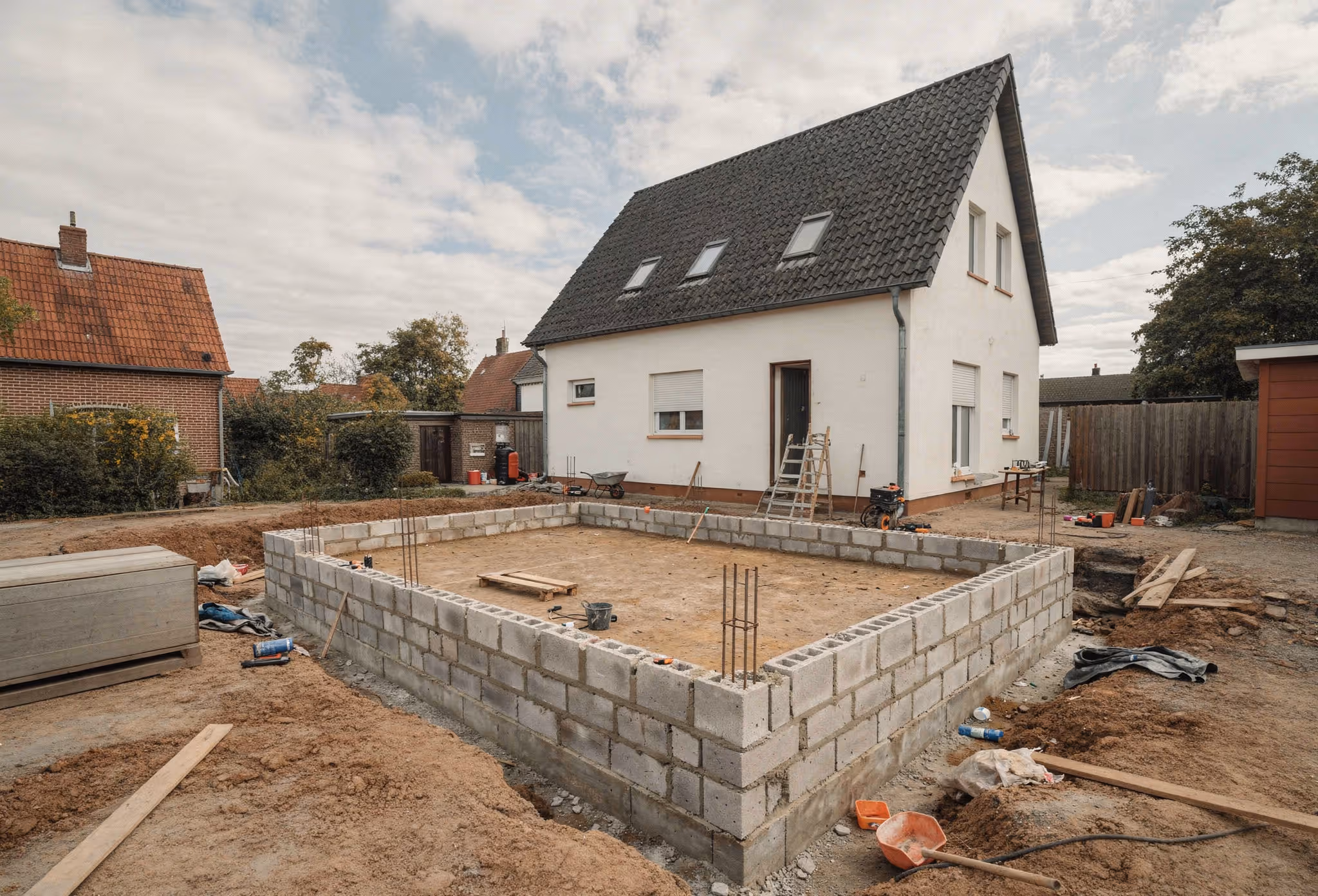 Vorbereitende Betonarbeiten im Außenbereich in Hamburg-Rahlstedt mit Schalungssteinen und Wohnhaus im Hintergrund